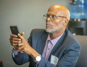 A man in a business suit using a smartphone at work environment.
