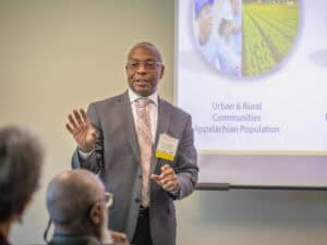 Accessible image of a professional speaker presenting on urban and rural communities to an engaged a.