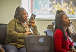 Engaged women attending a conference or seminar in a professional setting.