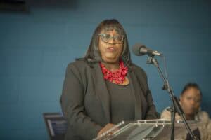 Empowered woman speaking at a podium during a conference or event.