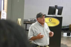 Agricultural expert giving a presentation at CAES News event, standing in front of a podium with uni.