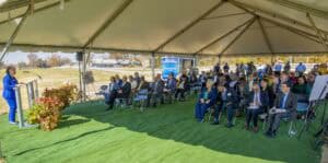 Innovative outdoor conference under a large tent with professionals and speakers engaging in a forma.