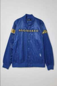 AGGIEBRED blue varsity jacket with yellow lettering and patches for college sports fans.