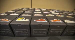 A table covered with black boxes, each labeled "THANK YOU," featuring colorful sneaker stickers on top.