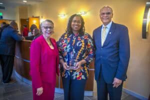 Celebrating achievement at CAES News event with diverse professionals and award presentation.