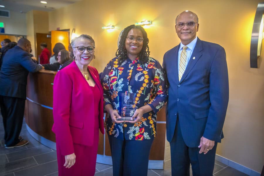 Celebrating achievement at CAES News event with diverse professionals and award presentation.