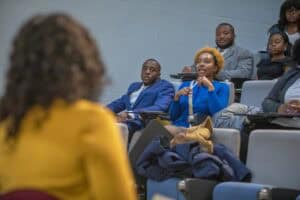 A group of students attentively engages in a discussion in a classroom setting.