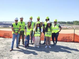 Construction team wearing safety vests and helmets at a building site.