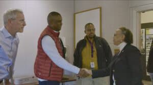 Business professionals shaking hands in a meeting room for networking and collaboration.