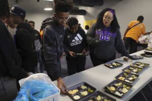 Healthy meal distribution event with diverse participants serving nutritious food. Community outreac.