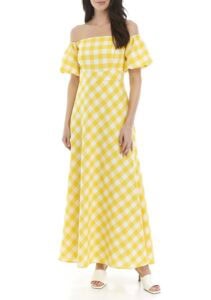 A woman wearing a yellow and white checkered off-shoulder maxi dress.