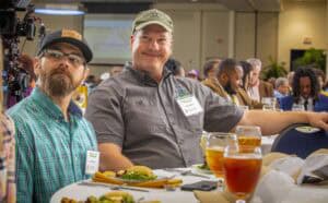 Engaged conference attendees enjoying food and networking at a professional event.