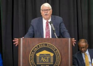 AET real estate foundation speaker at podium during conference in North Carolina.
