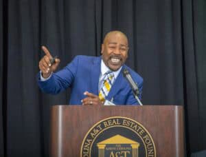Confident speaker at North Carolina A&T Real Estate Foundation event in a blue suit.