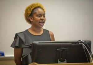 Empowered woman speaking at a conference or seminar about current news and issues.