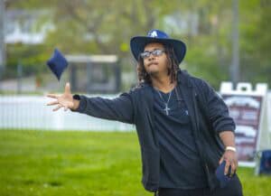 Throwing a cap in the air at outdoor event, celebrating achievement or graduation, casual attire, su.