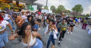 Vibrant outdoor community event with diverse people dancing and enjoying festivities.
