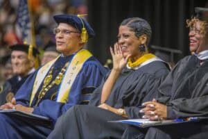Graduation ceremony with diverse graduates in academic regalia celebrating achievement.