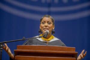 A woman speaking at a podium during a formal event or conference.