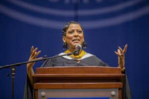 Empowered woman delivering speech at graduation ceremony with confidence and passion.