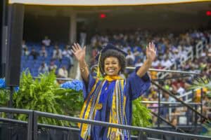 Graduation graduate celebrating success at commencement ceremony outdoors.