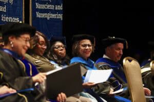 Graduates in academic regalia at a university commencement ceremony.
