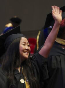Celebrating graduation with smiling student in cap and gown at commencement ceremony.