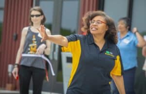 Accessible outdoor event with diverse participants, woman speaking passionately, engaging audience,.