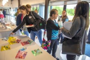 A woman selecting items from a table at a conference or event.