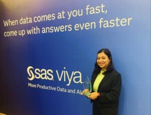 Fast data analysis and AI solutions at CAES News event with a smiling woman holding an award.