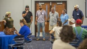 A woman speaking to an audience during a community event at CAES News.