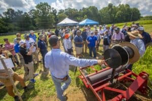 Organic farming demonstration with farmers and agricultural experts using a seed planter machine out.