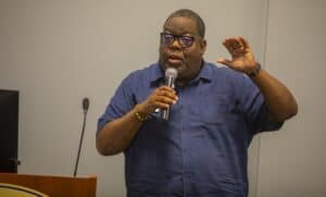 Engaged male speaker presenting at a conference or seminar, holding a microphone and gesturing with.