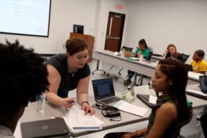 High school students participating in a classroom discussion with a teacher, focusing on education a.