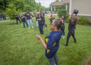 Community outdoor fitness event with women exercising and playing with a medicine ball.