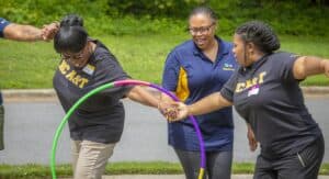 Hula hoop activity outdoors with smiling women at CAES News event.