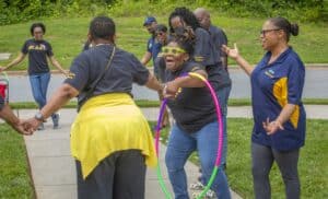 Happiness and teamwork at outdoor community event with diverse group of people.