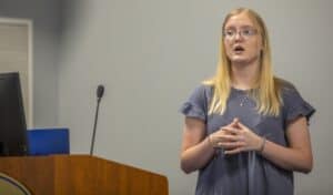 A woman giving a presentation at a conference or seminar.