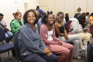Group of diverse women smiling at CAES conference in a professional setting.