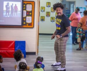 Engaging teacher speaking to young students in a classroom setting.