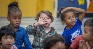 Bright-eyed children participating in a classroom activity, engaging in learning and discussion.