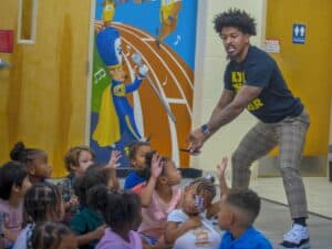 Motivational speaker engaging children in an indoor educational activity.