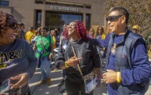 Students smiling and socializing outside B.C. Webb Hall at CAES News event.