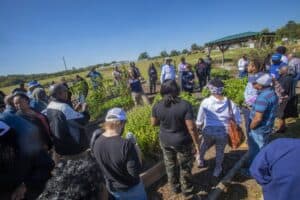 Organic farming workshop with diverse participants outdoors on a sunny day.