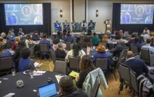 Engaging panel discussion at CAES News conference with diverse audience and speakers.