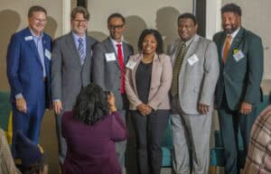 Engaged professionals at a conference or networking event, smiling and posing for a photo.