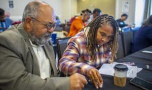 Diverse professionals collaborating during a workshop or seminar in a conference room.