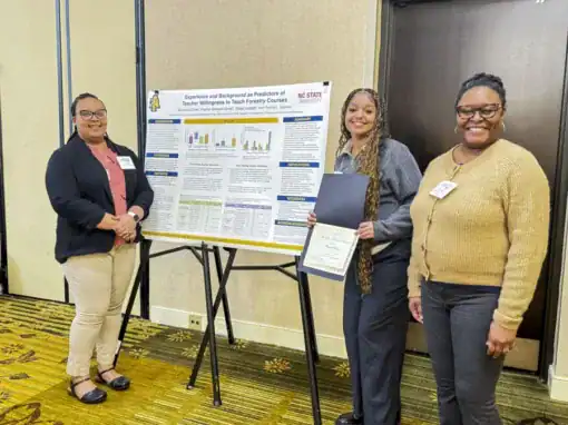 Three women stand in front of a research poster on teaching forestry courses. One holds a certificate, while the others smile at the camera. The background features a neutral-colored wall and a patterned floor.