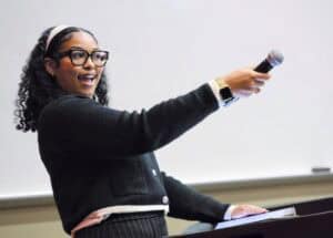 Empowered woman speaking into microphone during presentation or speech.
