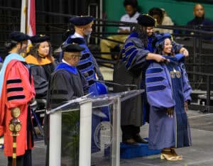 Graduation ceremony with faculty in academic regalia at CAES News event.